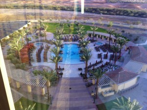 View from above of the hotel pool area and the grassy lawn beyond.